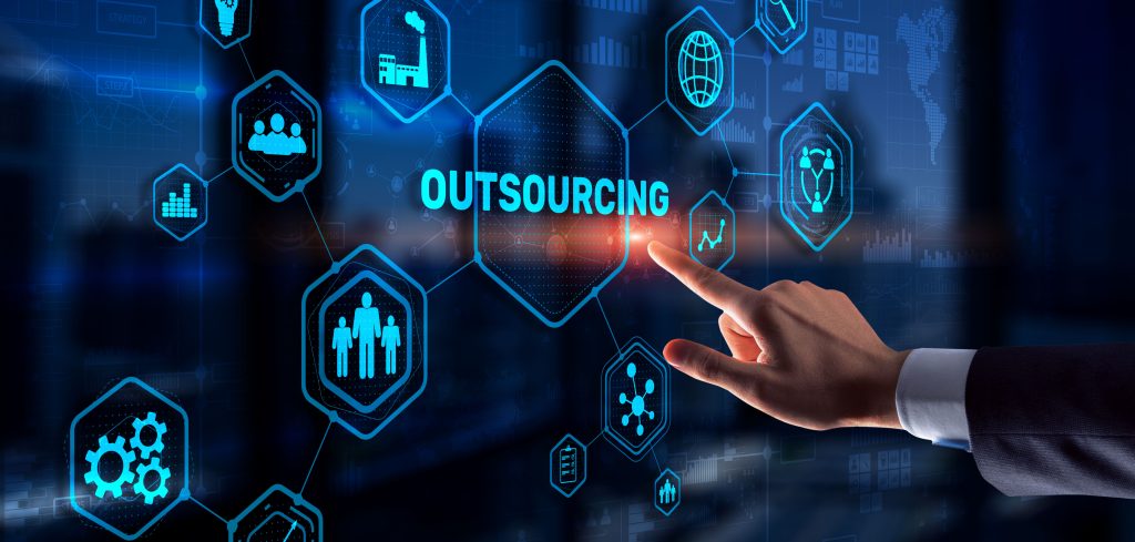 A businessman's hand pointing at outsourcing